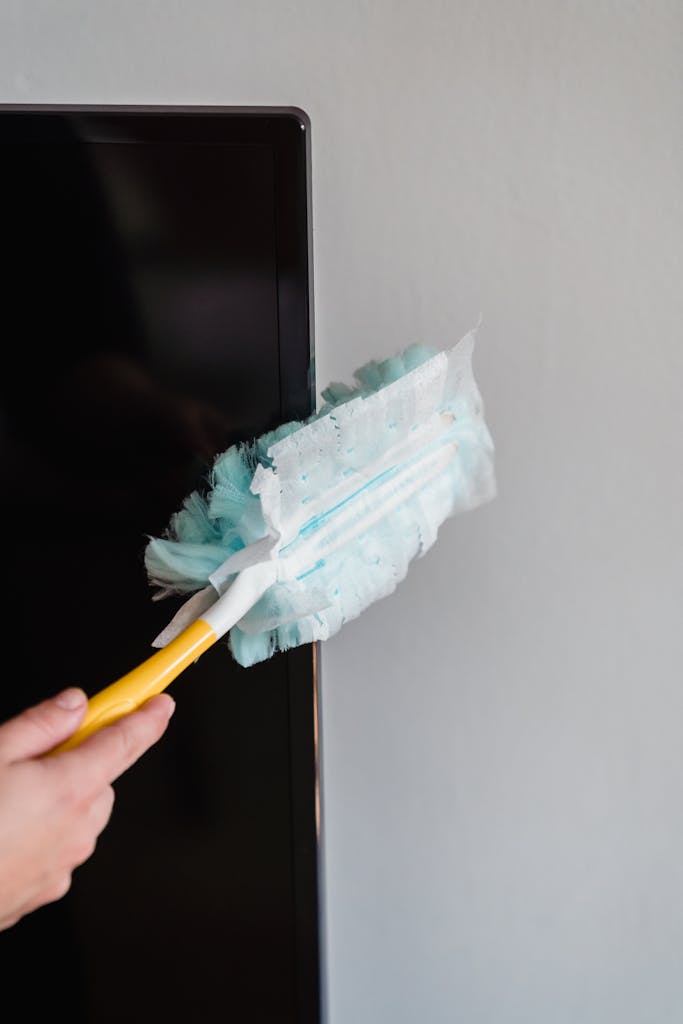 A Person Cleaning the Flat Screen TV